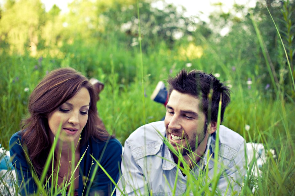 man and woman lying on the grass