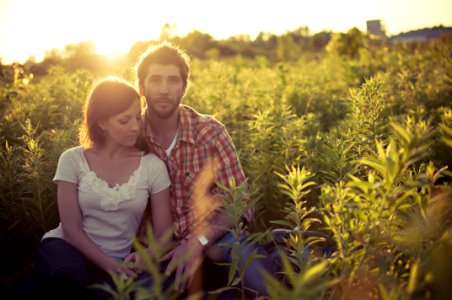man and woman sitting on grass field at daytime photo