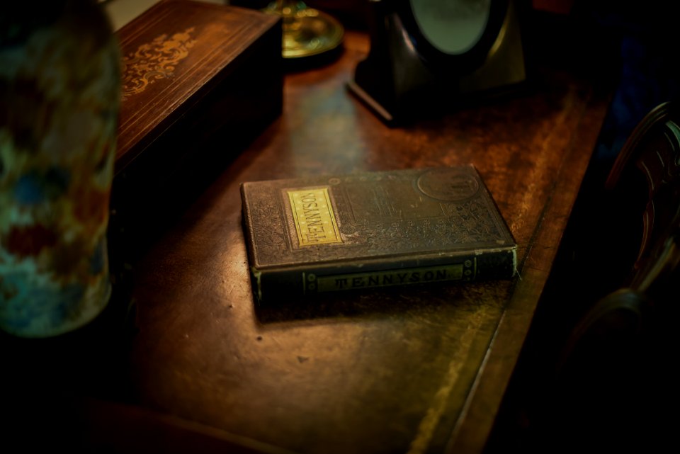 Tennyson covered book on wooden surface near box