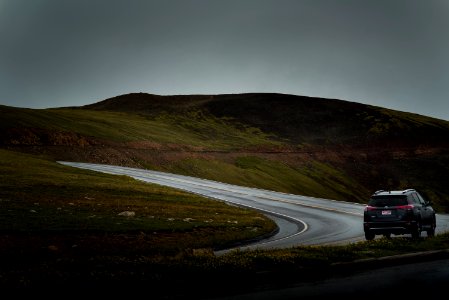 black SUV on curved concrete road near mountain at daytime photo