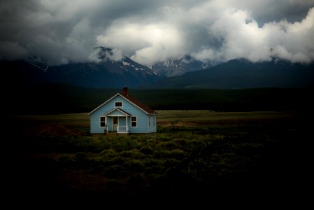 house on grass field under gray sky photo