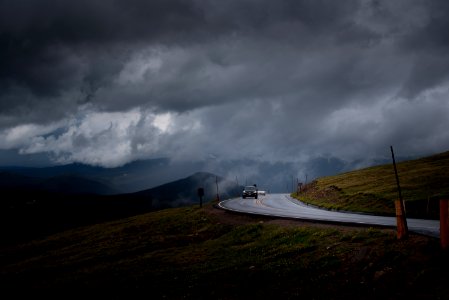 black car on gray asphalt road under cloudy sky photo