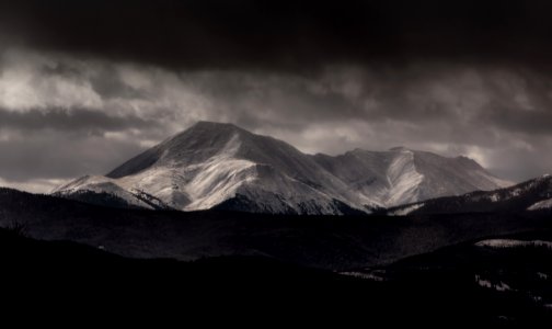 grayscale photography of mountain under cloudy sky