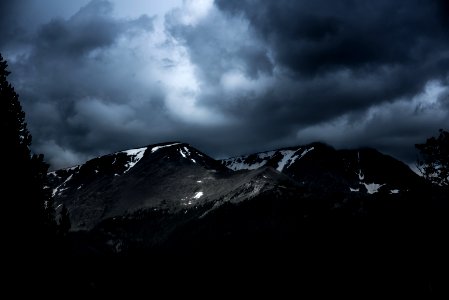 mountain range covered with snow under gray clouds photo