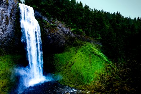 waterfalls plowing on rock formation near green trees photo