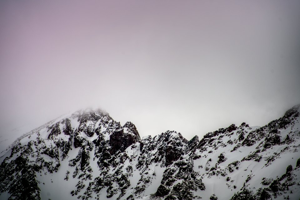 snow covered mountain under gray cloudy sky