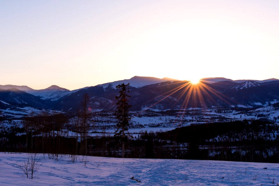 snow-covered mountains near plain area at sunset