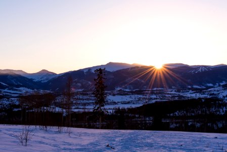 snow-covered mountains near plain area at sunset