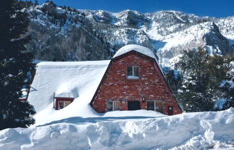 photo of brown brick house covered with snow photo