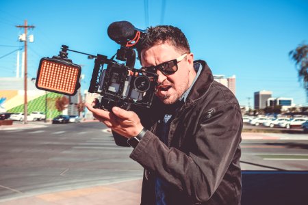 shallow focus photography of man holding video camera photo