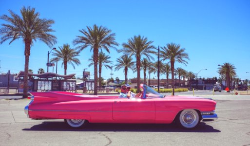 people in pink convertible coupe photo