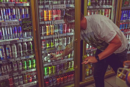 man getting can in beverage cooler photo