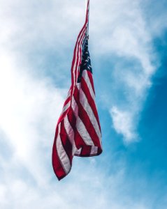 flag of the United State flying under white clouds photo