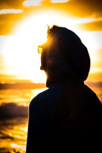 man wearing black hoodie during sunset photo
