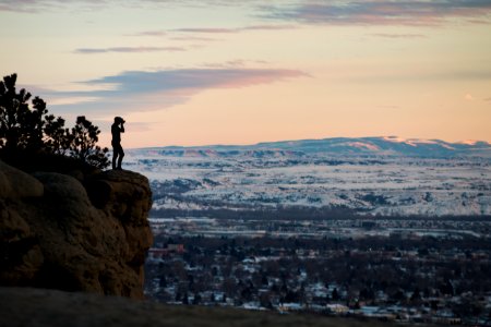 person standing on rock formation photo