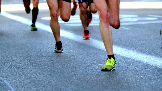 A shot of people's feet as they run on pavement.