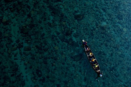 aerial photo of canoe on calm water with people