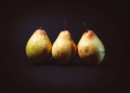 three pears on black surface photo