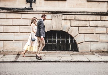 man and woman walking beside a road during daytime photo