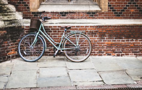 photo of parked blue commuter bike on gray brick wall photo