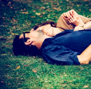 man and woman lying on grass photo