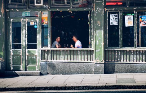 two person talking inside the bar during daytime photo