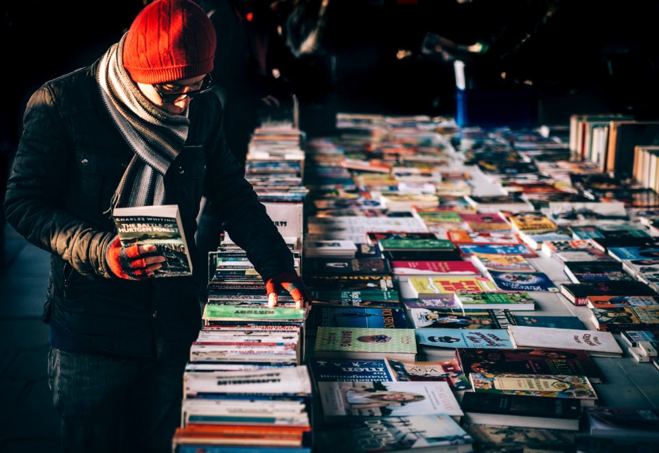 man picking up book ob book sale