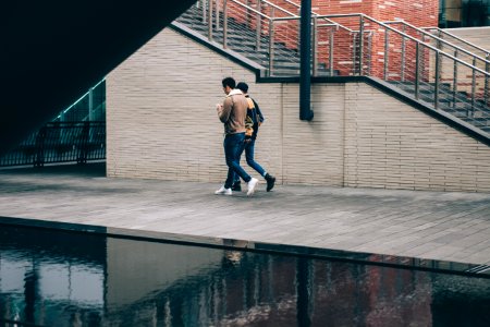 two man walking beside stair and body of water at daytime