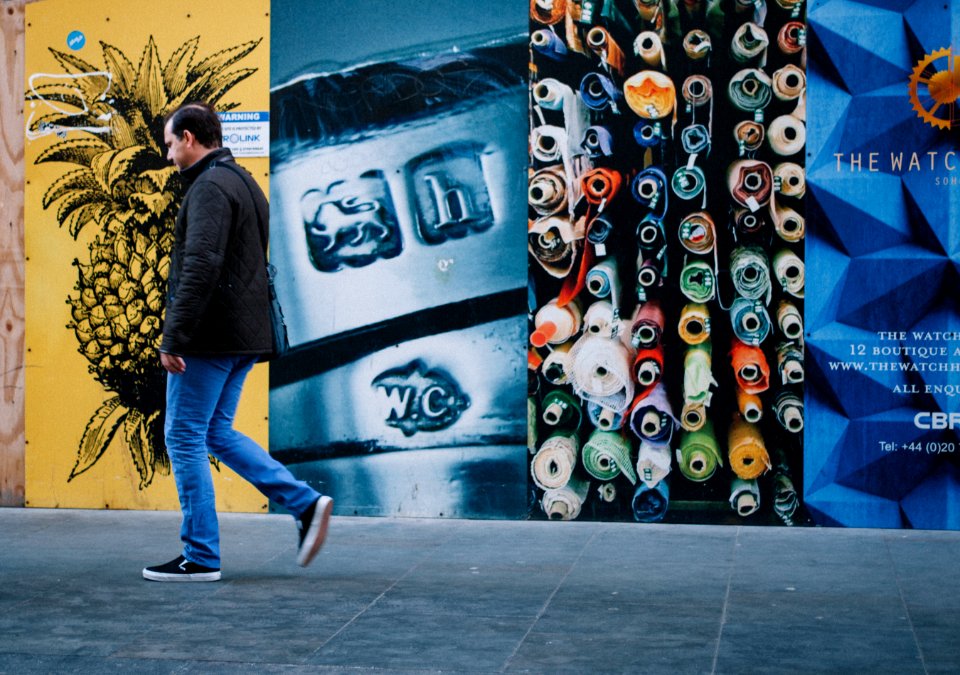 man walking near multicolored painted wall photo