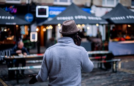 shallow focus photography of man walking in front of establishments photo