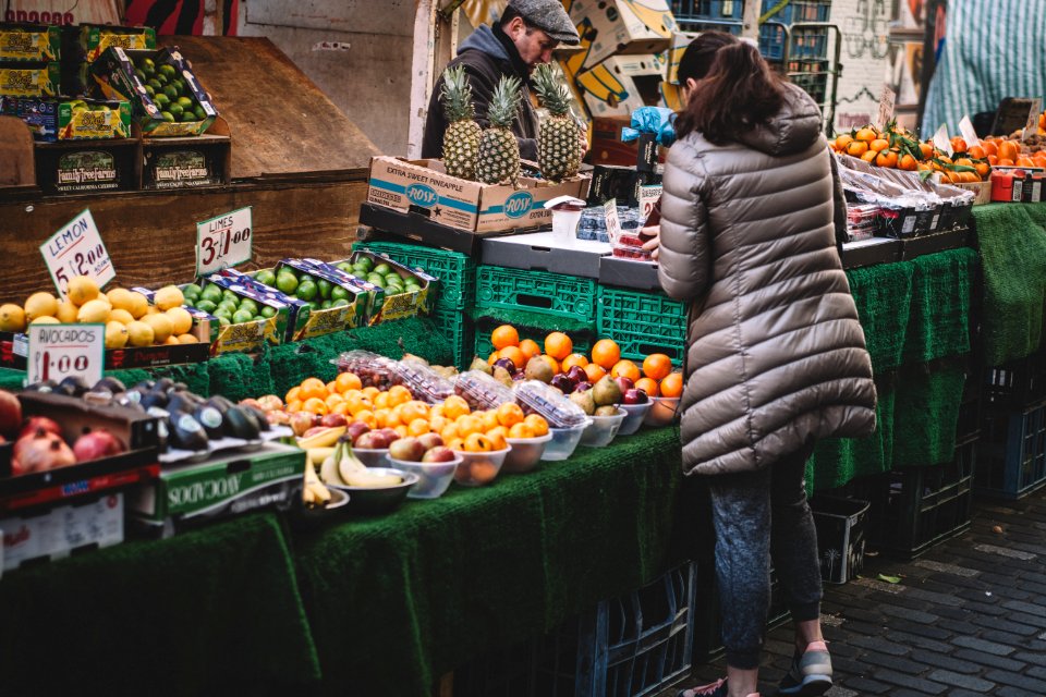 woman in front of fruit stands in market photo