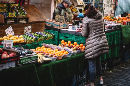 woman in front of fruit stands in market photo