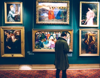 person standing near six paintings inside gallery photo
