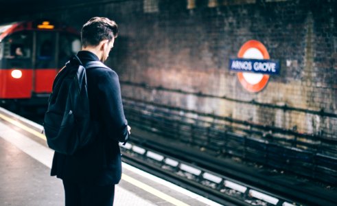 man with backpack standing on train station photo