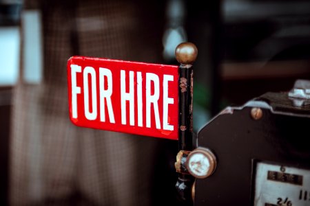 shallow focus photography of red and white for hire signage photo