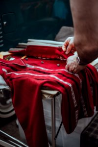 person holding red button-up dress shirt