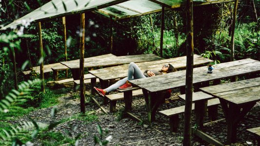 woman lying on gray wooden picnic table photo