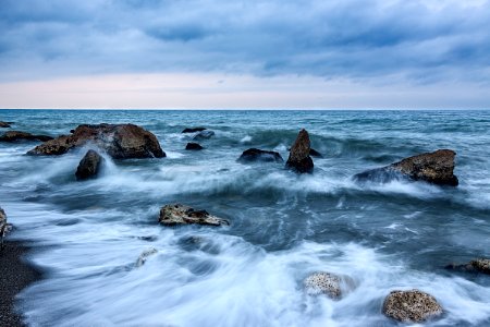 photo of a dancing waves with rocks photo