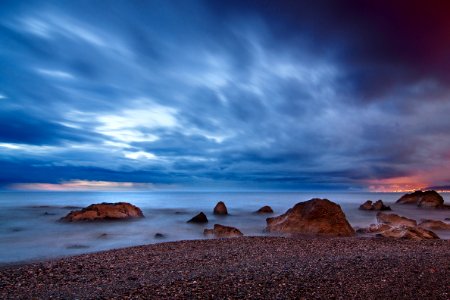 rocks at seashore under clouds photo