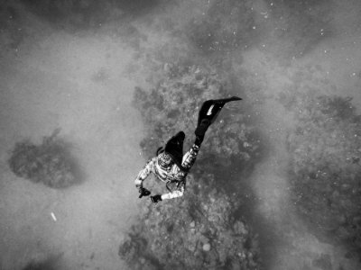 grayscale photo of man about to dive on body of water photo
