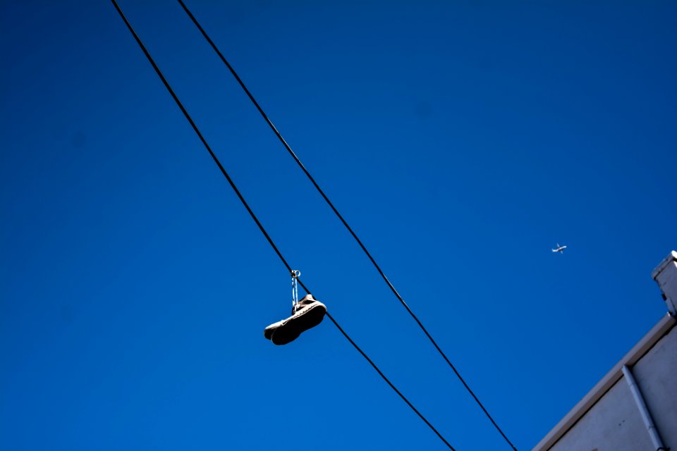 unpaired shoe hanging on cable