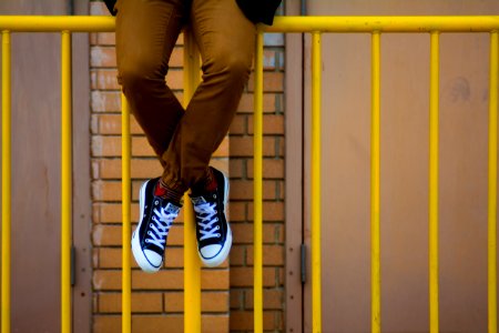 person sitting on rail fence photo