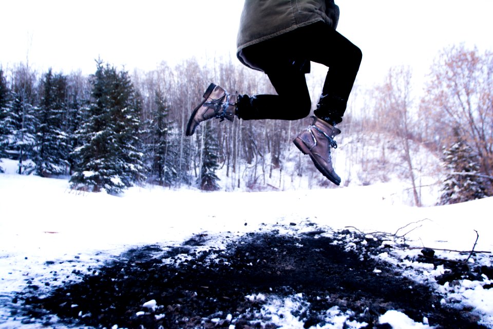 person jumping over black soil