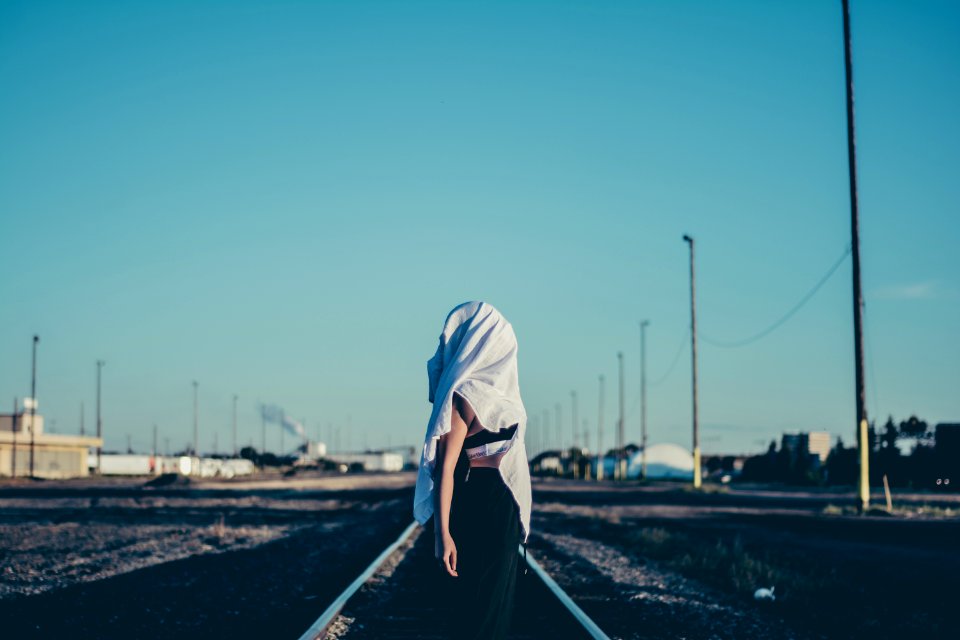 woman standing in the middle of train rail photo