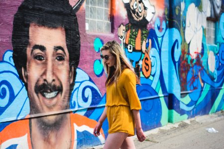 woman walking beside wall with graffiti photo