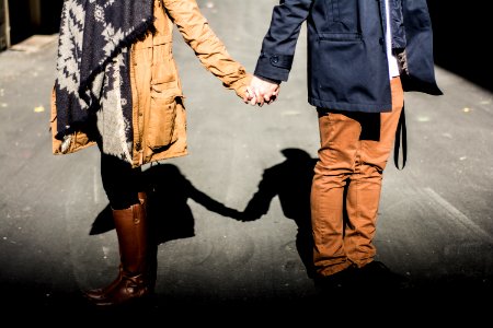 man and woman standing while holding hands at daytime photo