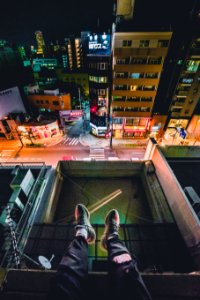 man sitting on rooftop overlooking city photo