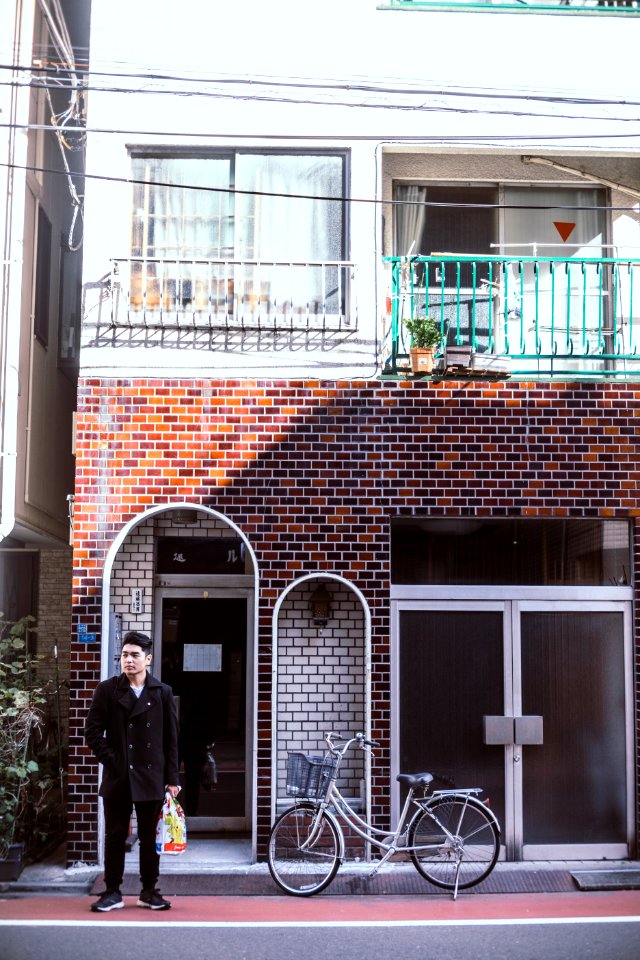 man wearing black jacket beside bicycle