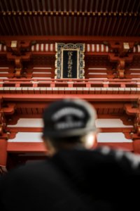 person wearing black cap in front of tower