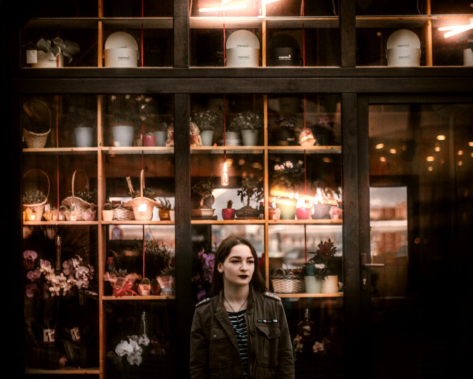woman in black leather jacket standing beside glass cabinet